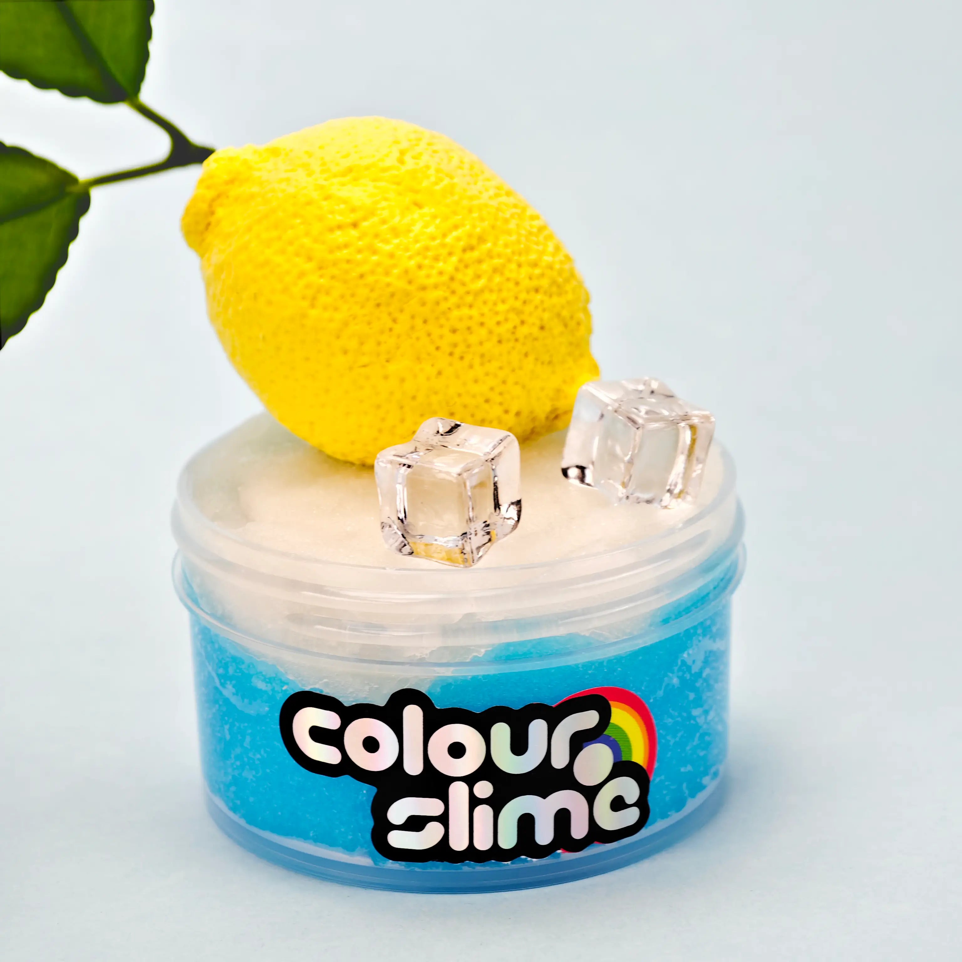 Jar of 'colour slime' with a lemon korean clay and ice cubes on a light blue cloud slime