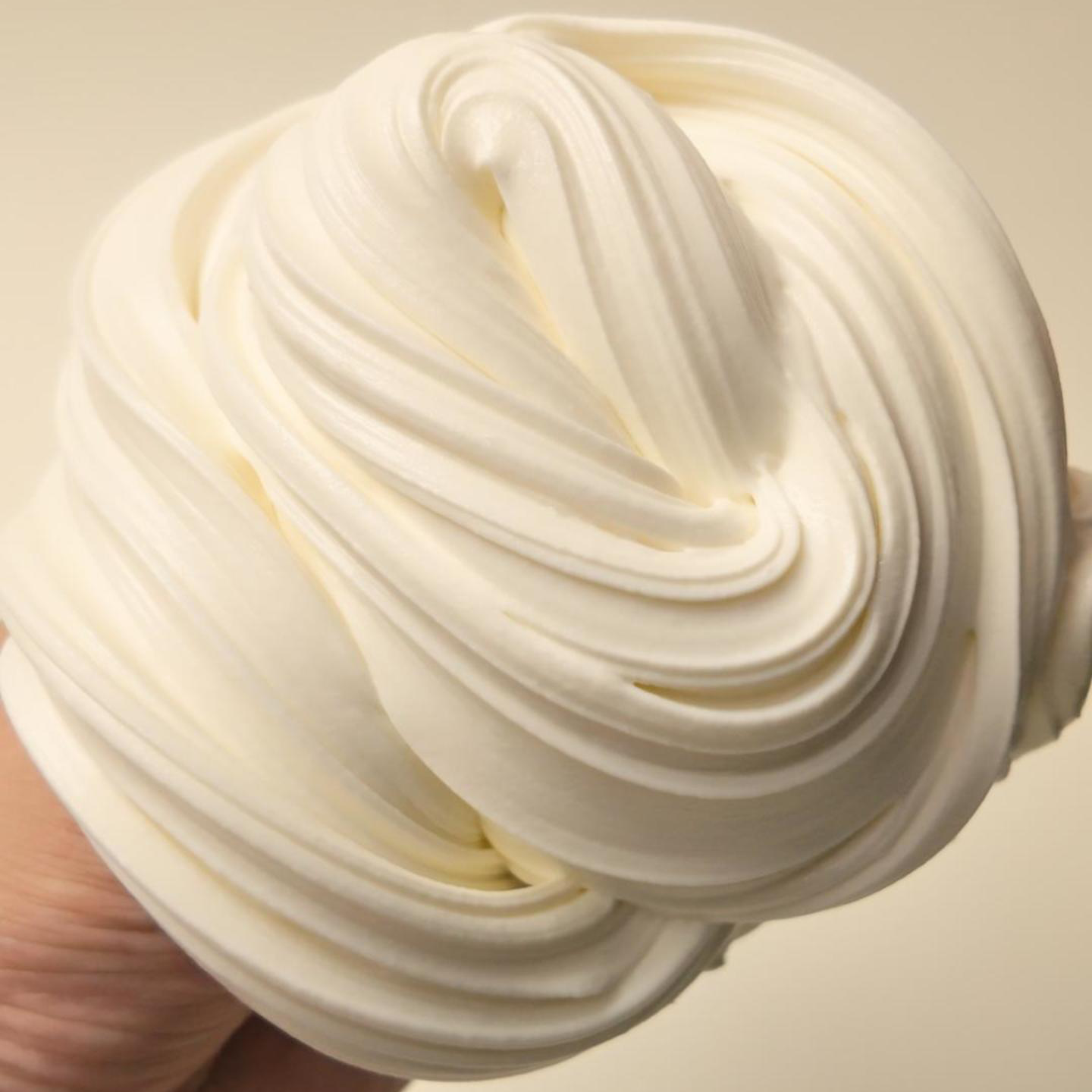 Vanilla Whip white glue slime stretched into soft, airy, cream-colored folds with a smooth whipped texture